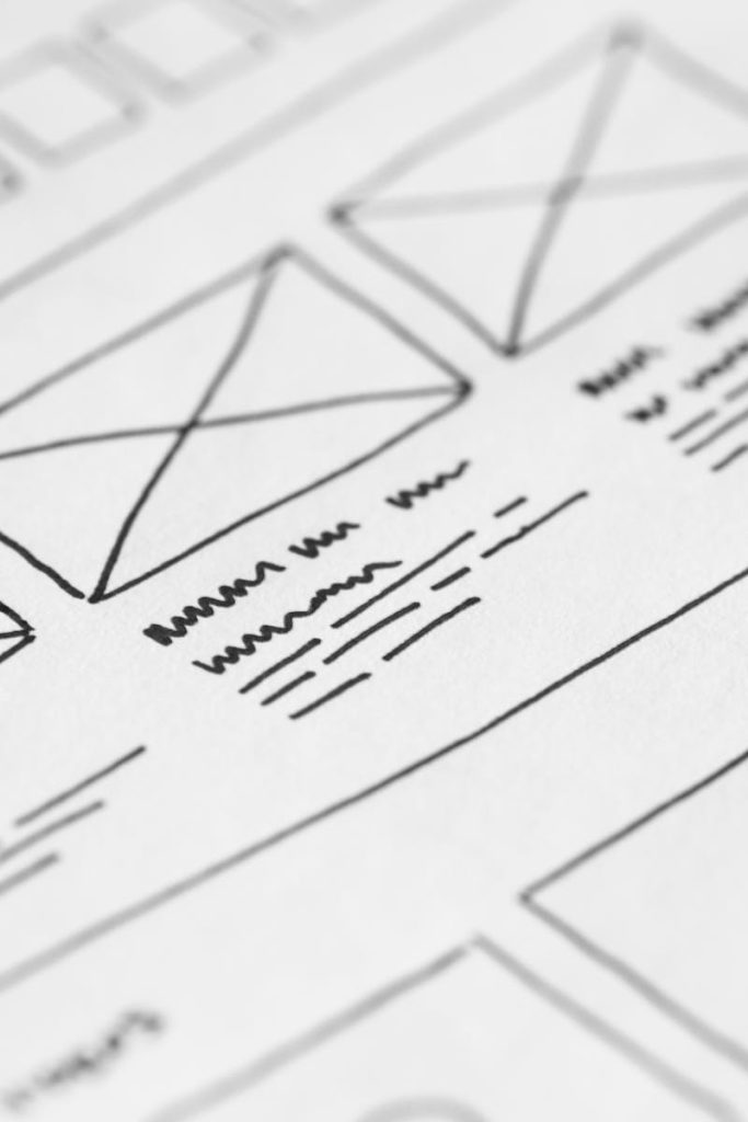 pexels-photo-196645-196645-1 Detailed close-up of a hand-drawn wireframe design on paper for a UX project.
